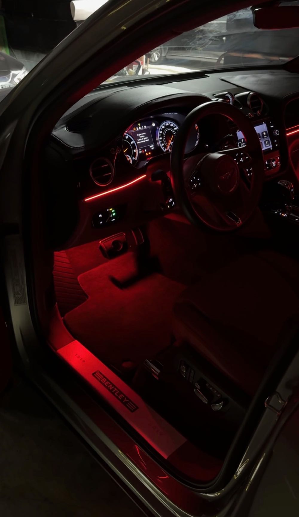 Red ambient lighting across the dash and footwell of a Bentley Bentayga