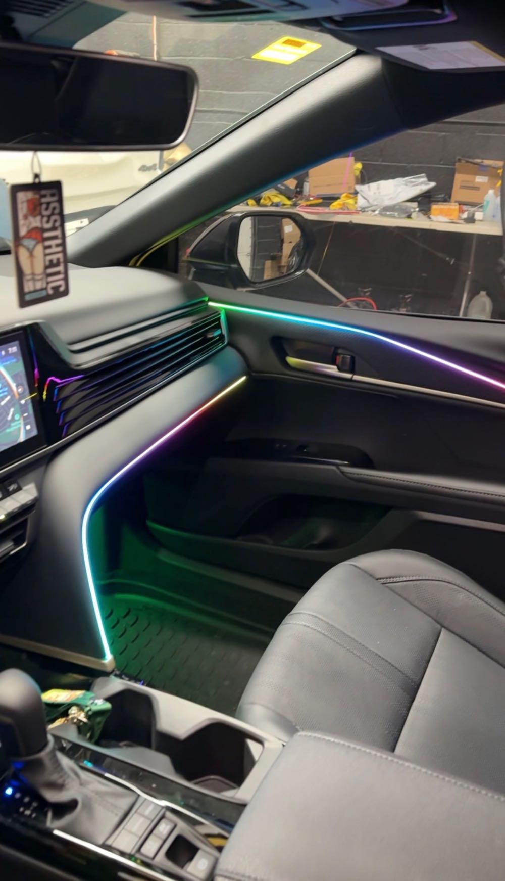Full-color ambient lighting along the door and dash of a sedan